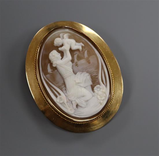 A 750 yellow metal mounted oval cameo brooch, carved with a lady with cherub, signed? on back, (Finnish gold marks), 57mm.